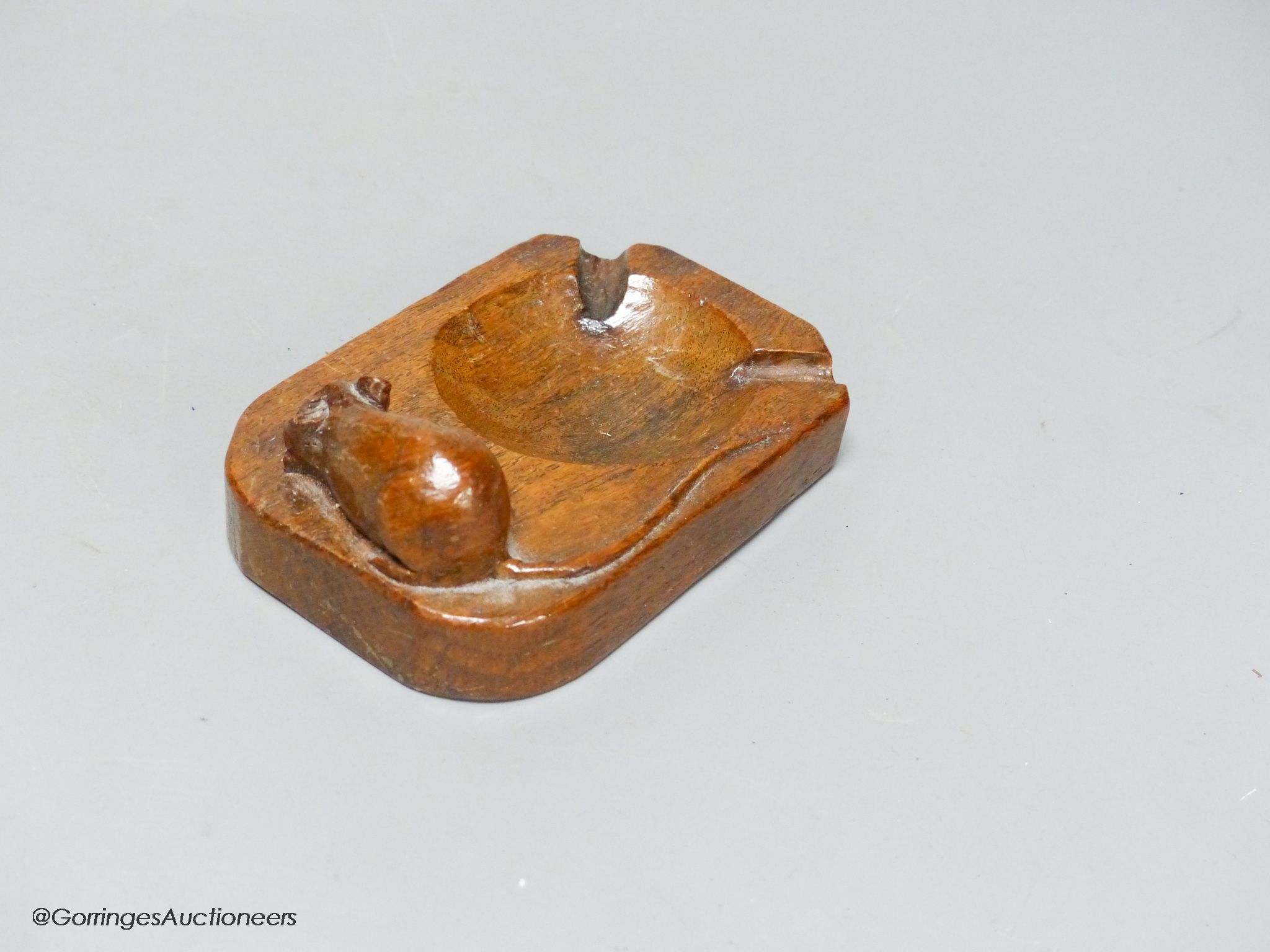 A Mouseman oak ashtray, width 10cm, slight loss to ear